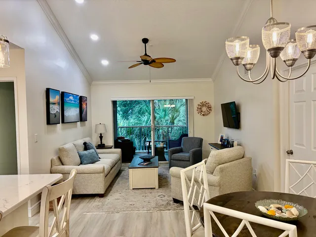 a living room with furniture a flat screen tv and a window