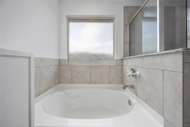 a bathroom with a white bath tub and a shower
