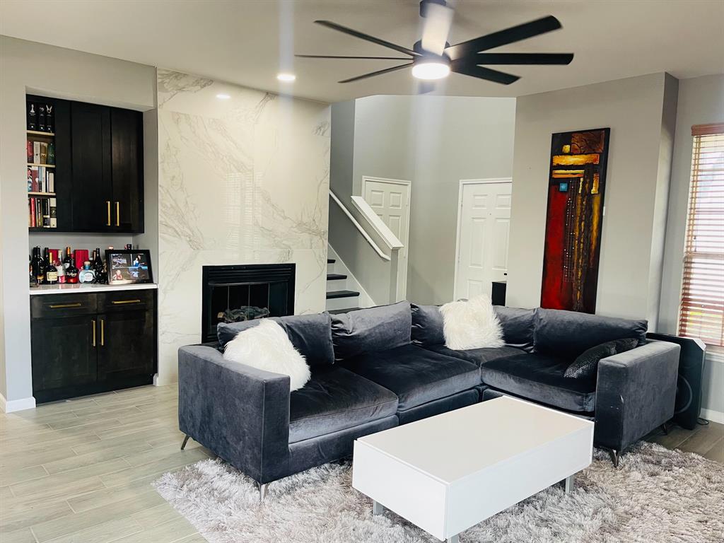 516 Angela Lane Euless, TX 76039 - Photo 13 of 39 Living room featuring light wood-style flooring, a ceiling fan, stairway, a high end fireplace, and recessed lighting