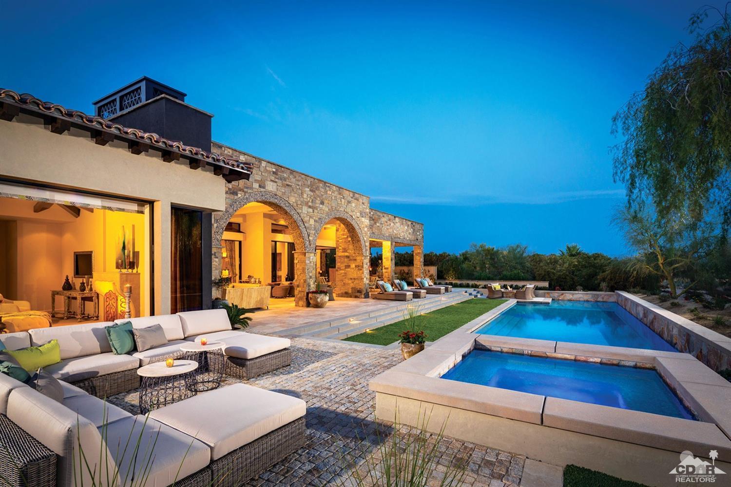 a view of swimming pool with outdoor seating and house in the background