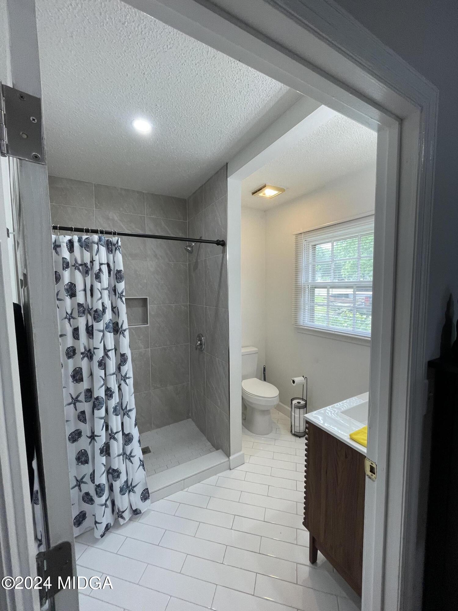 4064 Emory Drive Macon, GA 31206 - Photo 24 of 37 a bathroom with a bathtub and a shower