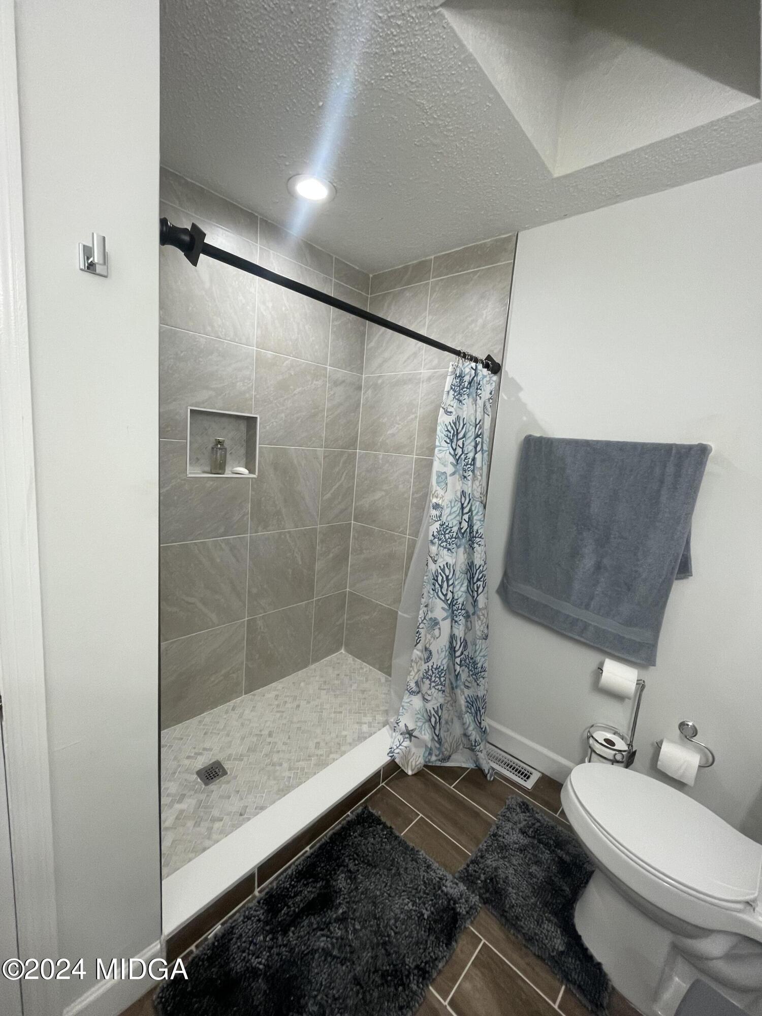 4064 Emory Drive Macon, GA 31206 - Photo 27 of 37 a bathroom with a granite countertop sink a toilet and shower