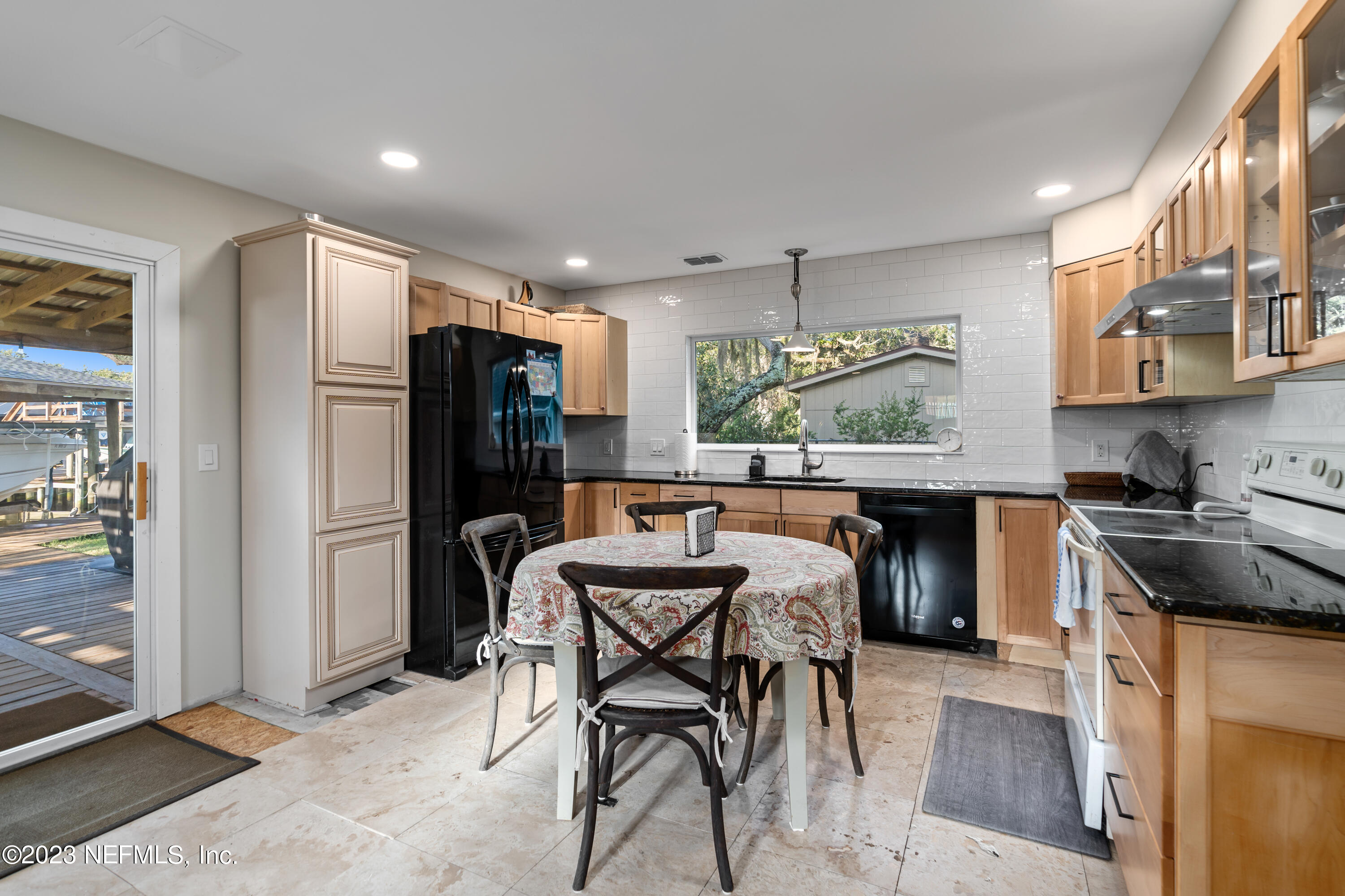 281 Ole Road St. Augustine, FL 32080 - Photo 39 of 61 a kitchen with granite countertop a refrigerator a stove a sink a dining table and chairs with wooden floor