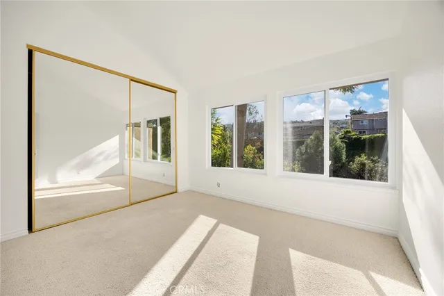 an empty room with windows and mirror