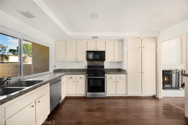 a kitchen with granite countertop white cabinets and stainless steel appliances