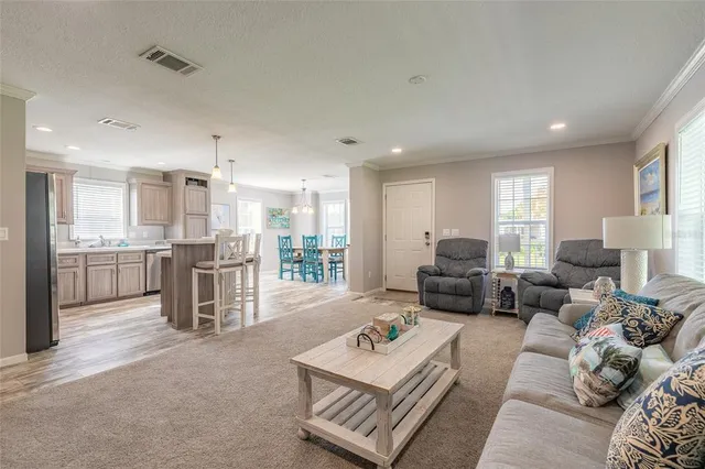 a living room with furniture and a kitchen view