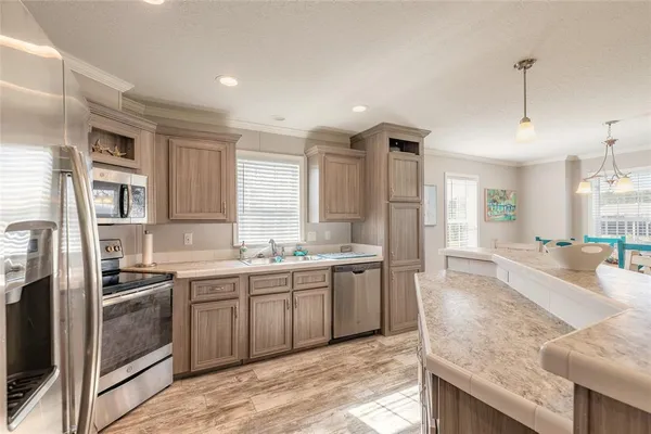a large kitchen with kitchen island a sink stainless steel appliances and cabinets