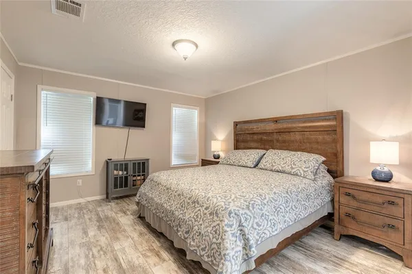 a bedroom with a bed and a tv on table