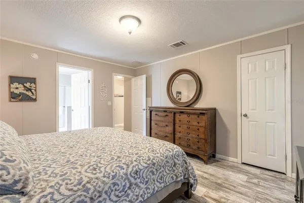 a bedroom with a bed a mirror and a table