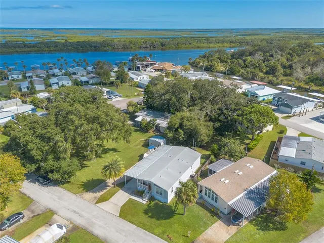 an aerial view of residential houses with outdoor space and ocean view