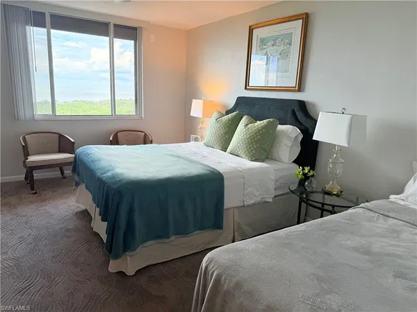 a bedroom with a bed and a large window