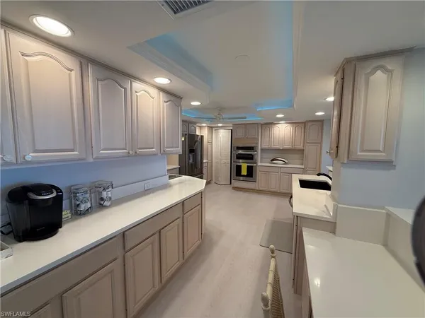 a kitchen with stainless steel appliances granite countertop a sink refrigerator and cabinets
