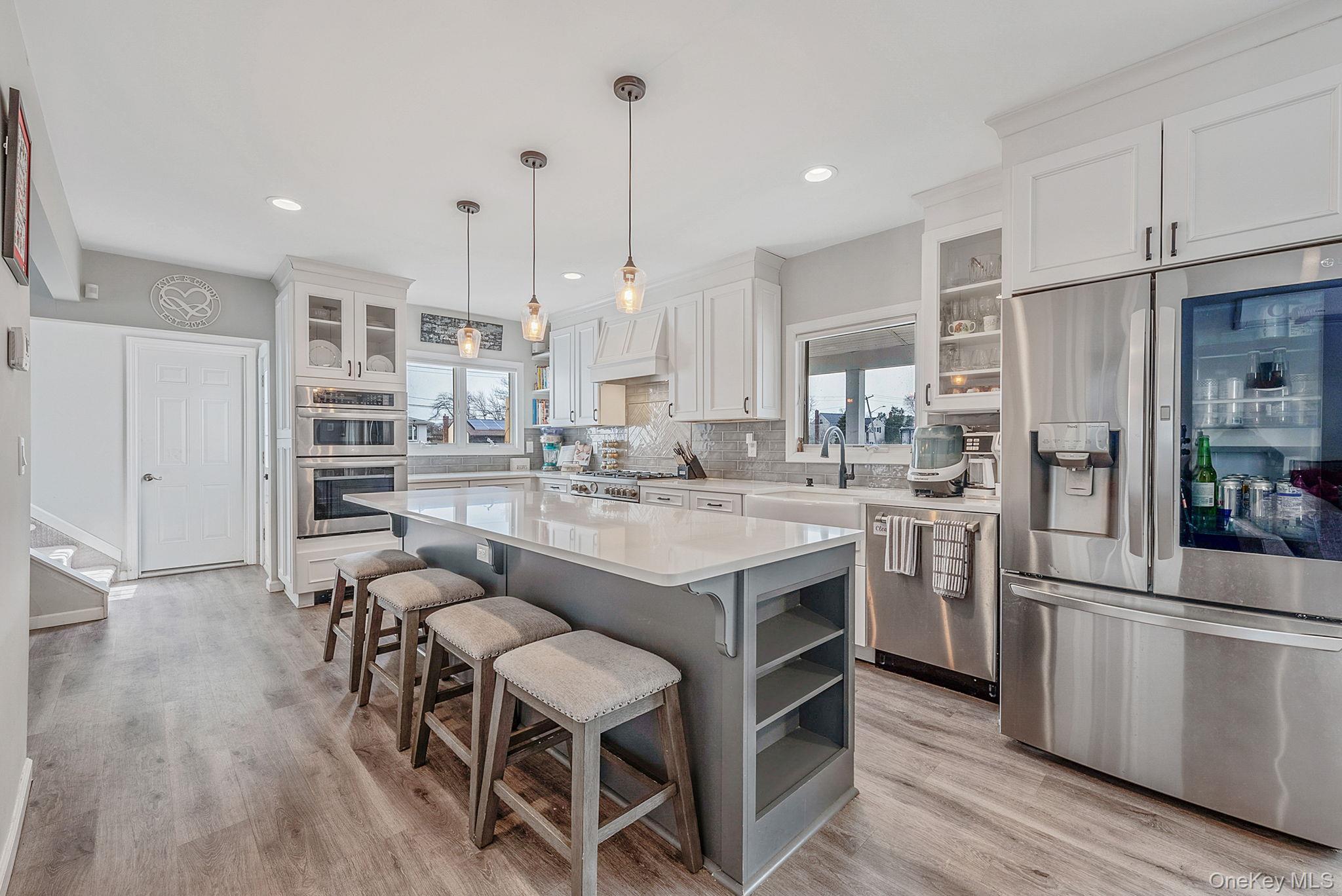 794 Pecan Street Lindenhurst, NY 11757 - Photo 20 of 44 a kitchen with stainless steel appliances granite countertop a table chairs stove and kitchen island