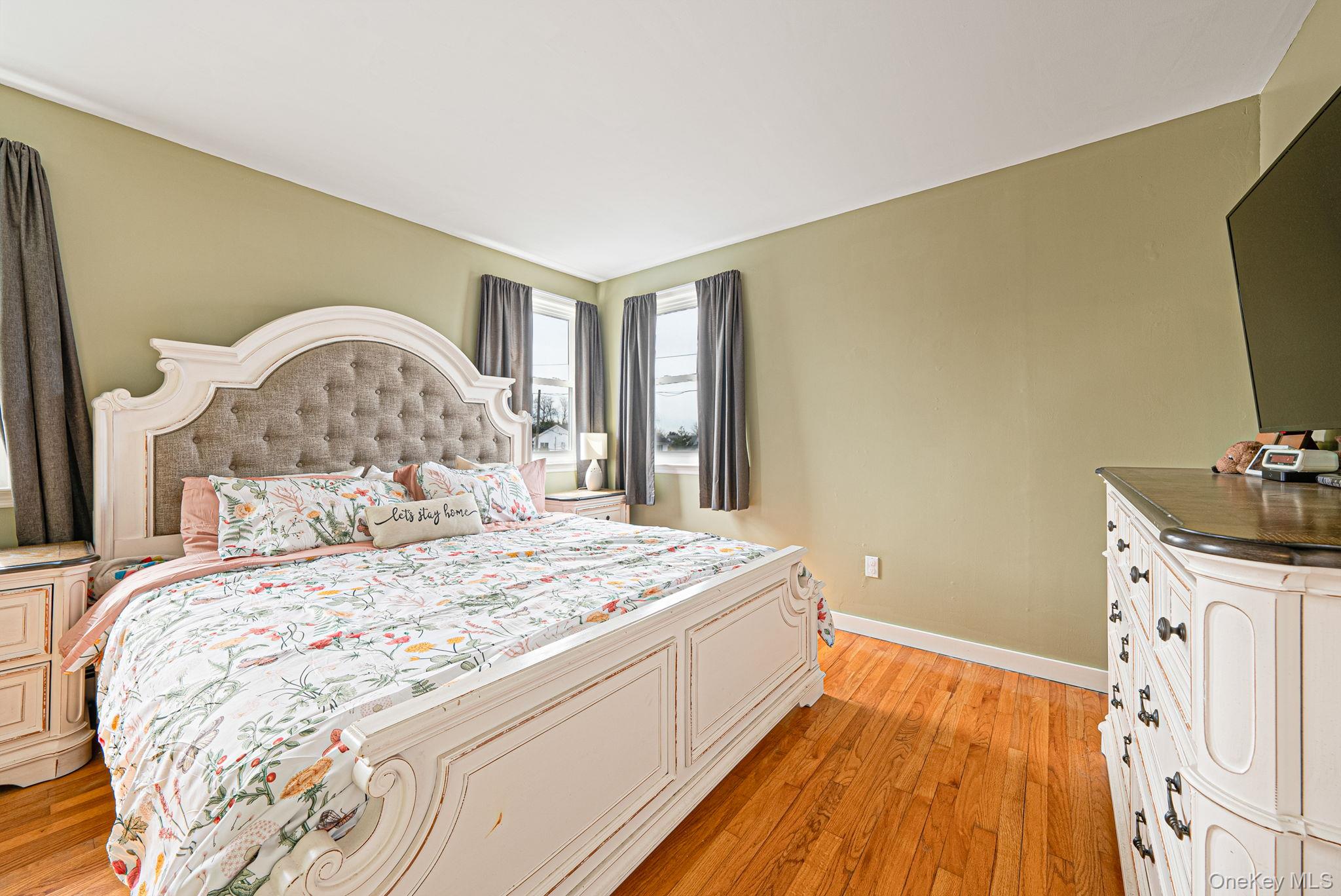 794 Pecan Street Lindenhurst, NY 11757 - Photo 29 of 44 a bedroom with a bed and a flat tv screen on dresser