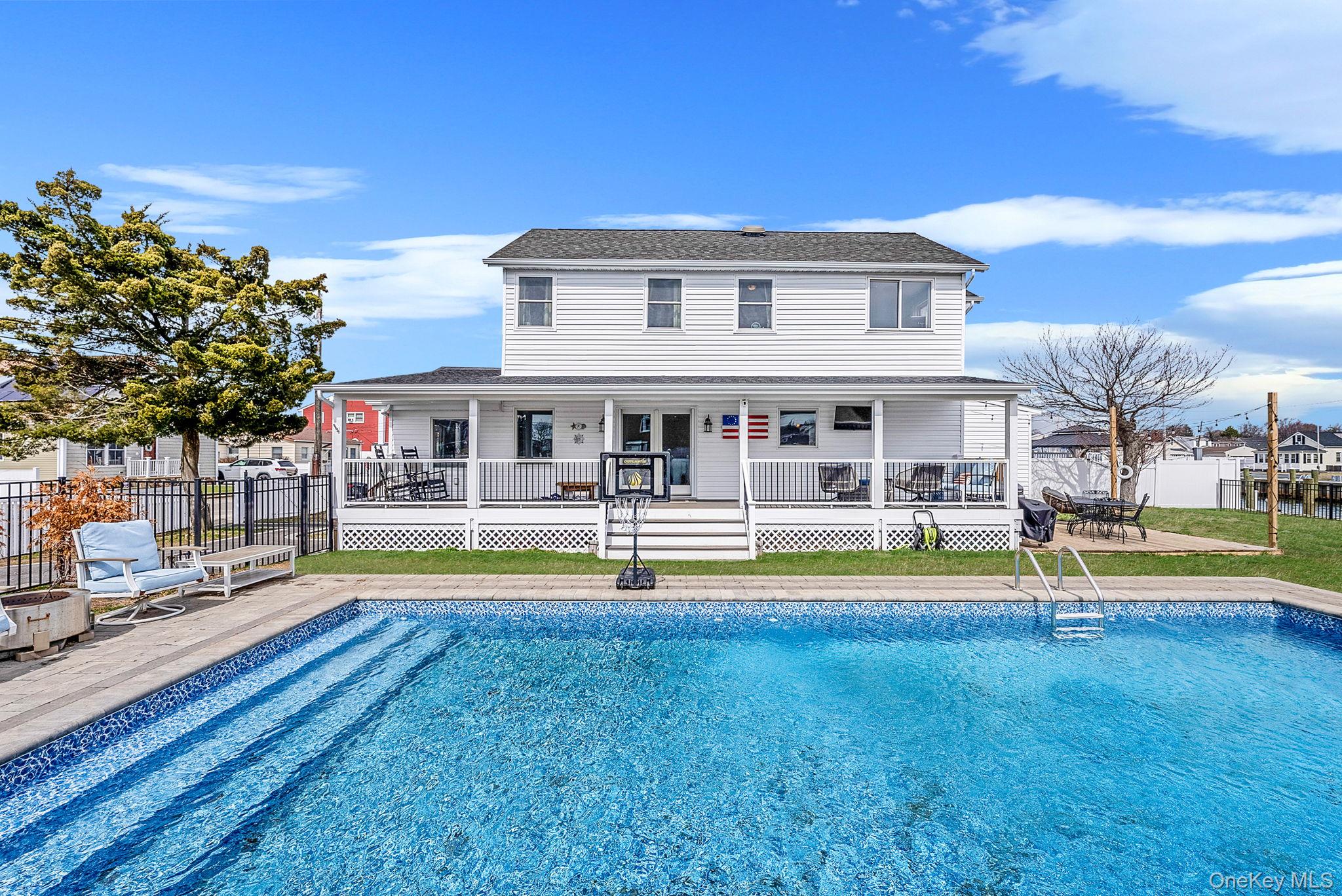 794 Pecan Street Lindenhurst, NY 11757 - Photo 8 of 44 a view of pool with lawn chairs and large trees