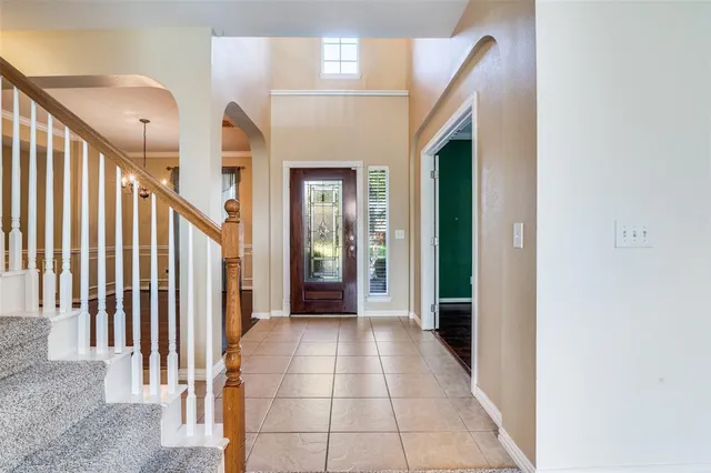 a view of a hallway with entryway and stairs