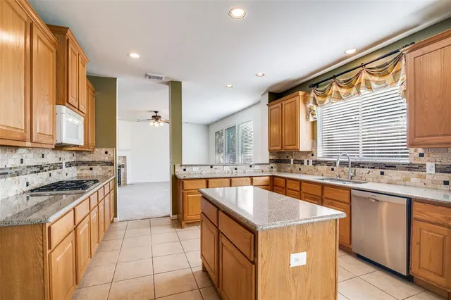 a kitchen with a sink stove top oven and cabinets