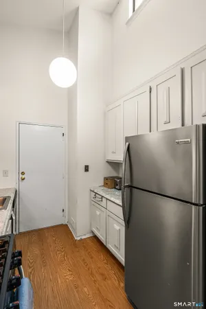 a kitchen with a refrigerator a stove top oven and cabinets