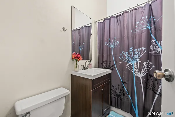 a bathroom with a toilet a sink and curtain