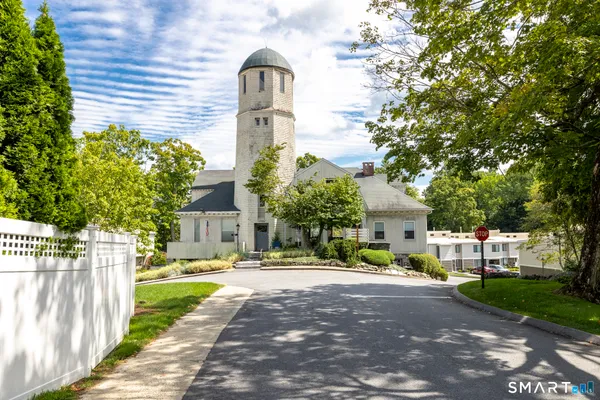 a front view of a house with a garden and tree