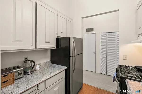 a kitchen with stainless steel appliances granite countertop a refrigerator and a stove