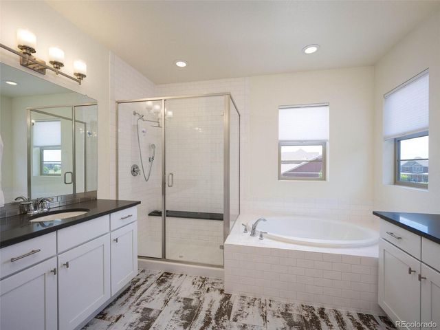 a spacious bathroom with a tub sink shower and mirror
