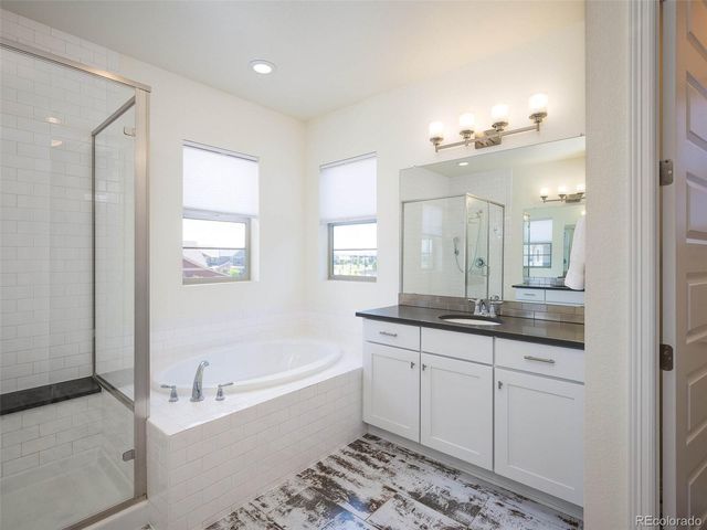 a bathroom with a granite countertop sink mirror and a bathtub