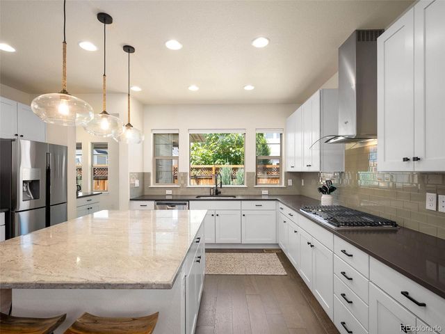 a large kitchen with kitchen island lots of counter space a sink appliances and cabinets