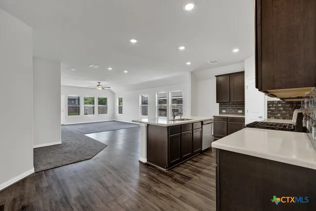 a large kitchen with granite countertop a large counter top stainless steel appliances and cabinets