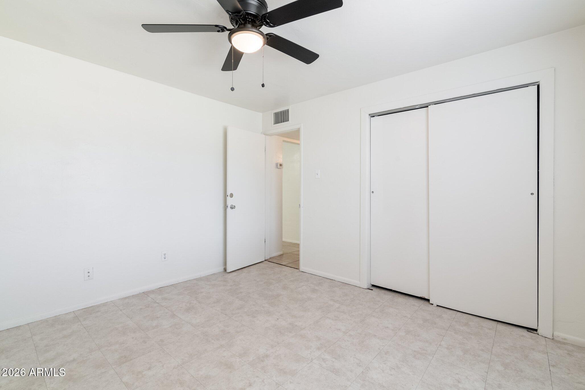 1335 East Broadway Road Mesa, AZ 85204 - Photo 13 of 23 an empty room with chandelier fan