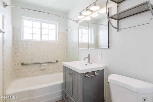 an empty room with a window and a ceiling fan