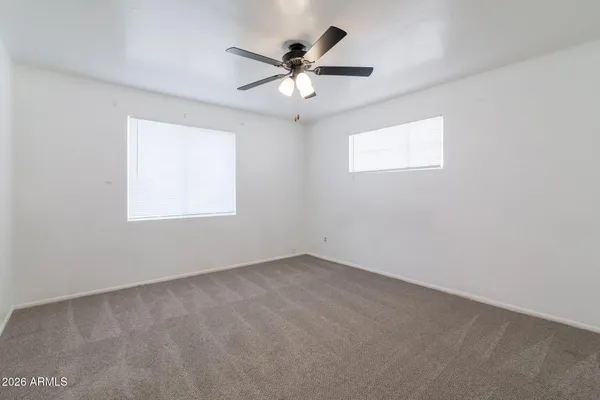 an empty room with chandelier fan