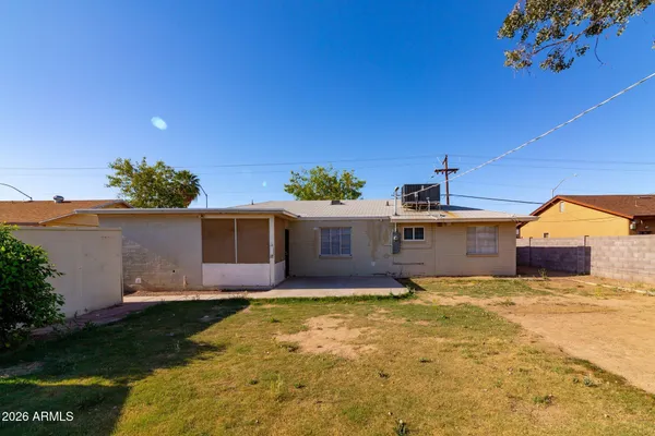 a view of a house with a small yard and a wooden fence