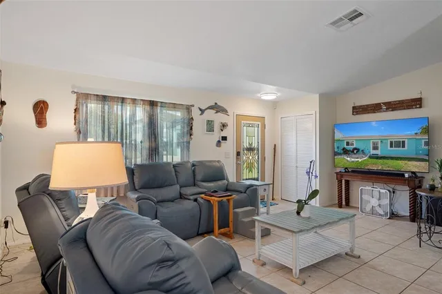 a kitchen with stainless steel appliances granite countertop a refrigerator a stove a sink dishwasher a dining table and chairs with wooden floor