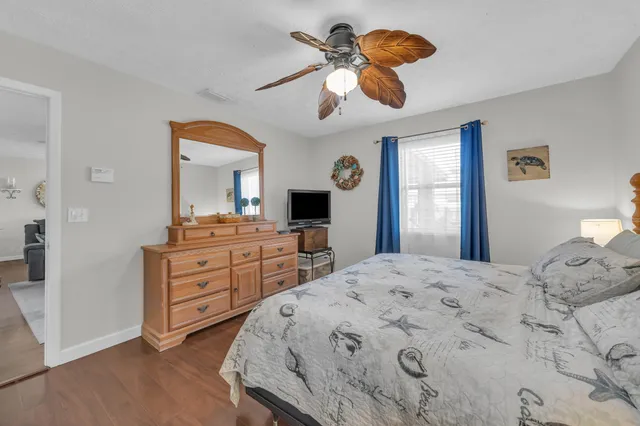 a bedroom with a bed chandelier and a window