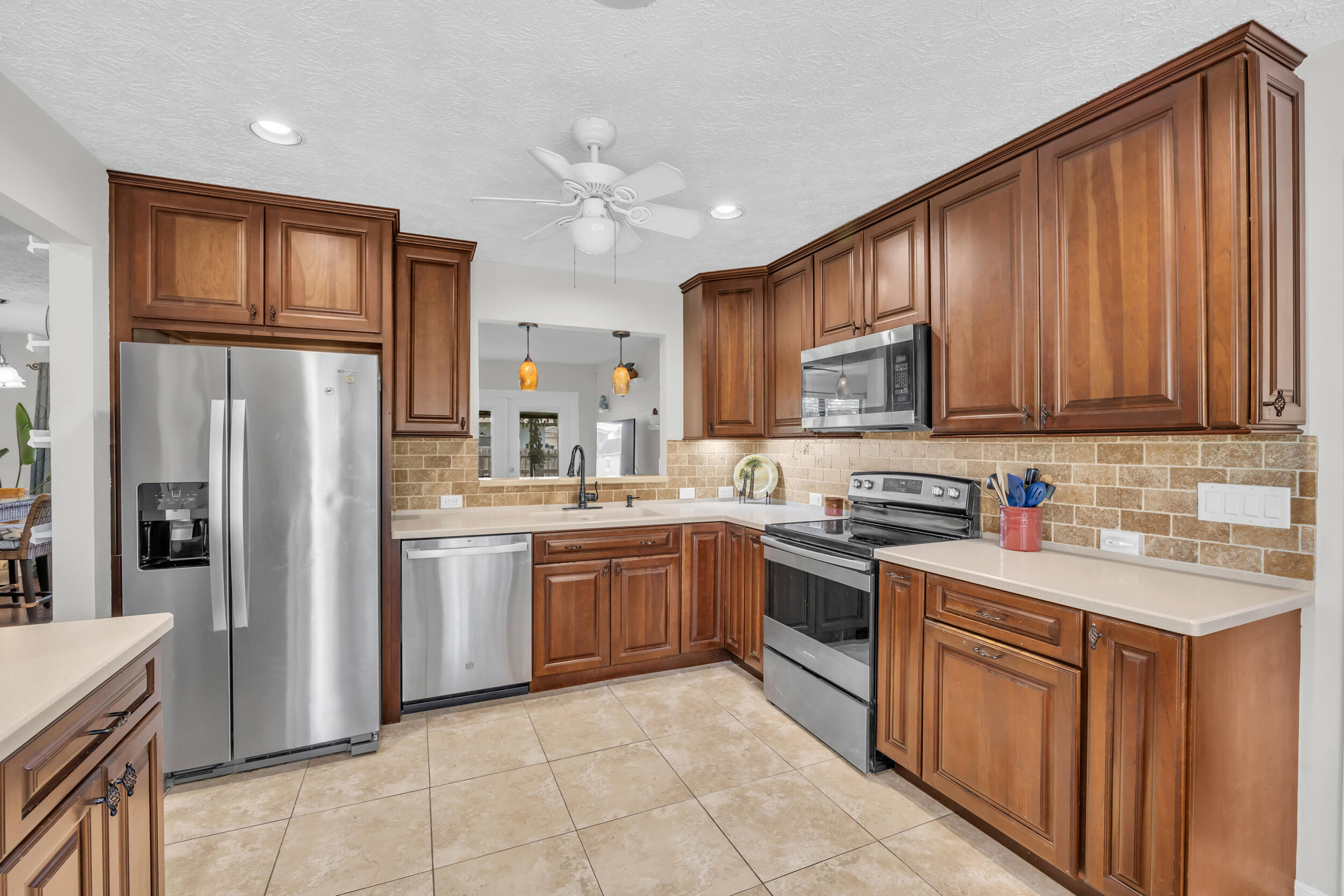 261 Southwest Chelsea Terrace Port St. Lucie, FL 34984 - Photo 5 of 25 a kitchen with stainless steel appliances granite countertop a refrigerator stove top oven and sink