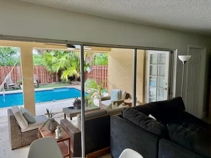 a living room with furniture and a floor to ceiling window