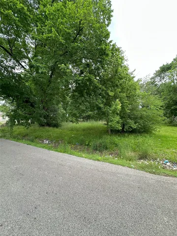 a view of a field with trees in background