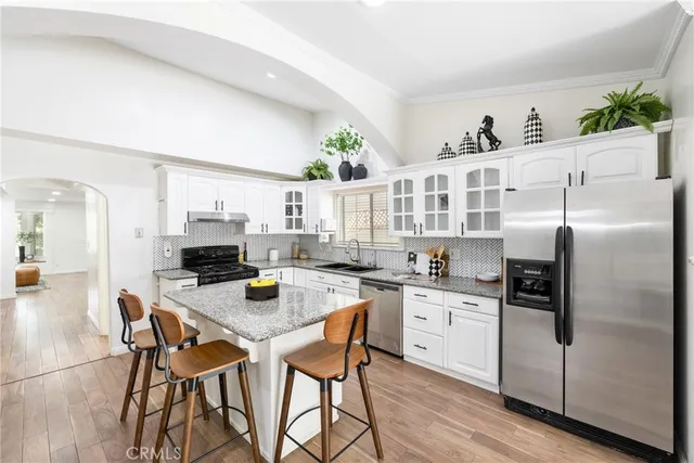 a kitchen with stainless steel appliances granite countertop a refrigerator and a stove top oven