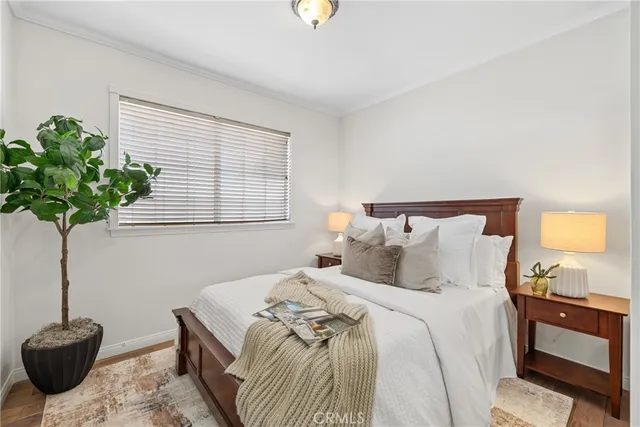 a bedroom with bed and a potted plant