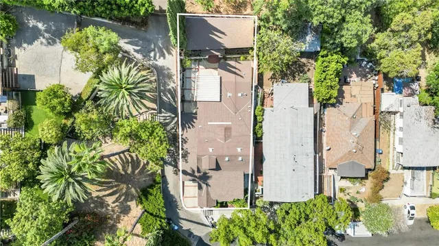 an aerial view of residential house with outdoor space and trees all around