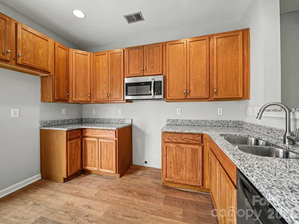 a kitchen with stainless steel appliances granite countertop wooden cabinets a sink and dishwasher