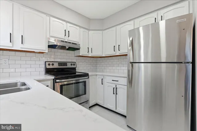 a kitchen with stainless steel appliances a refrigerator sink and cabinets
