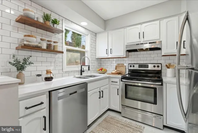 a kitchen with cabinets stainless steel appliances and a sink