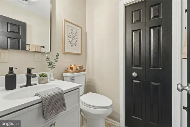 a bathroom with a granite countertop toilet sink and mirror