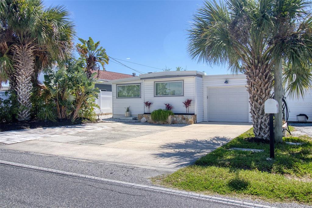 6820 Sea Ranch Drive Hudson, FL 34667 - Photo 2 of 29 a front view of a house with garden and trees