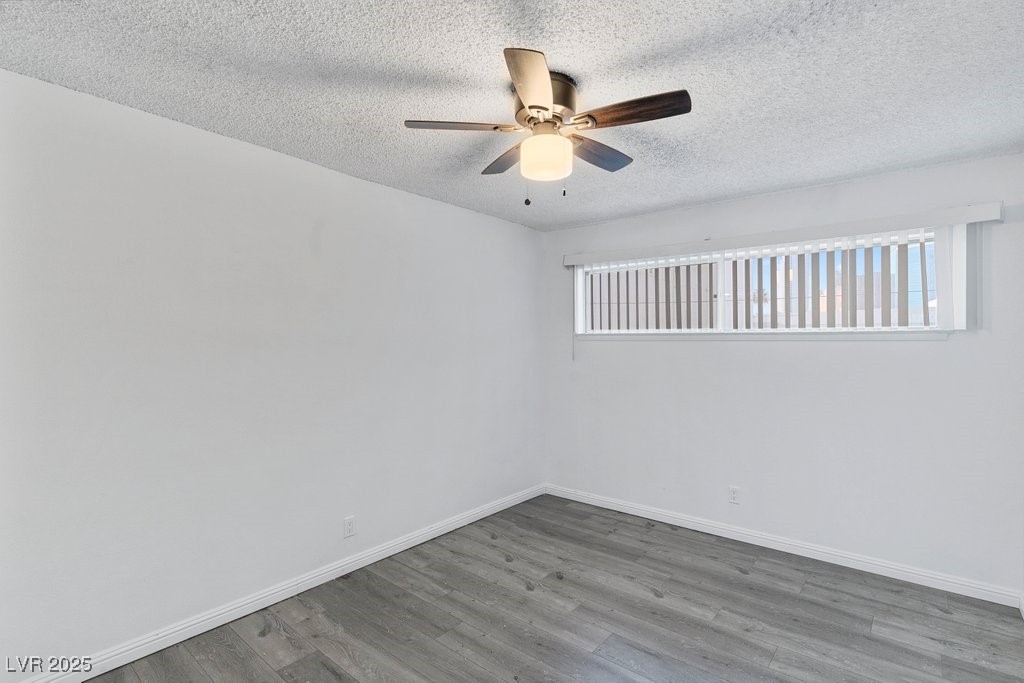 350 East Desert Inn Road, Unit H205 Las Vegas, NV 89109 - Photo 13 of 30 Spare room featuring a textured ceiling, wood finished floors, and ceiling fan