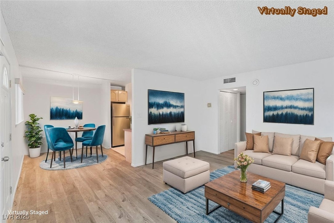 350 East Desert Inn Road, Unit H205 Las Vegas, NV 89109 - Photo 3 of 30 Living room with light wood-type flooring and a textured ceiling