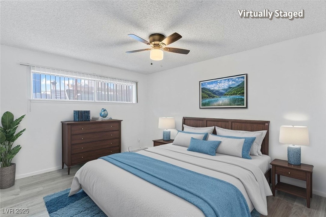 350 East Desert Inn Road, Unit H205 Las Vegas, NV 89109 - Photo 4 of 30 Bedroom with wood finished floors, a ceiling fan, and a textured ceiling