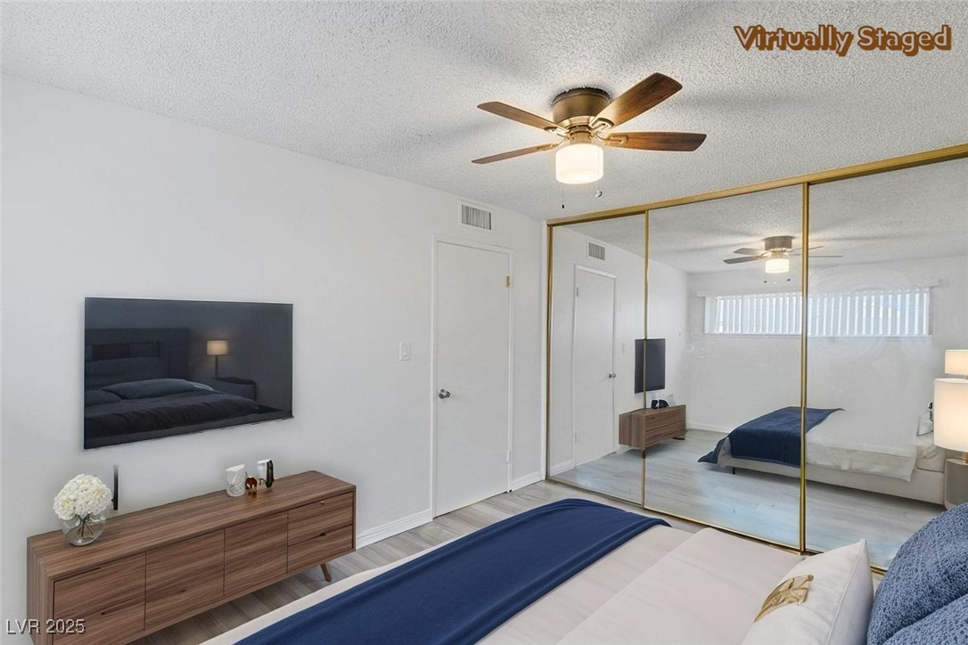350 East Desert Inn Road, Unit H205 Las Vegas, NV 89109 - Photo 5 of 30 Bedroom with a textured ceiling, wood finished floors, a closet, and a ceiling fan